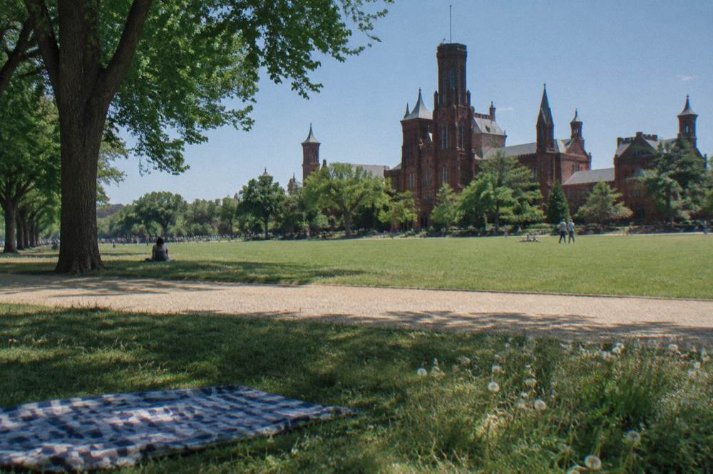 Smithsonian castle building on a clear afternoon with green lawn in front