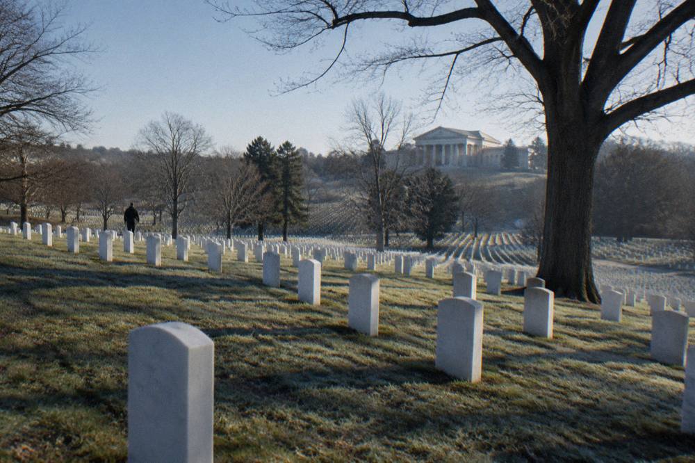White marble headstones in even rows stretching across a grassy hillside