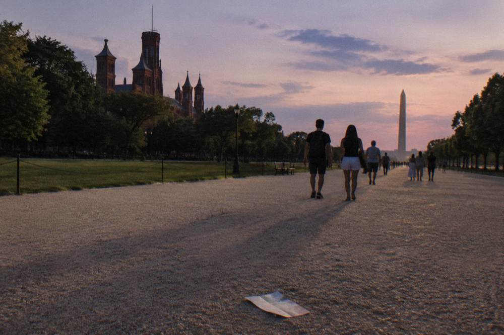 Visitors walking along the National Mall toward the museum corridor in late afternoon light