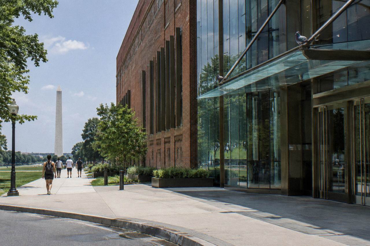 Museum of the Bible building exterior with glass atrium and brick facade under a clear sky
