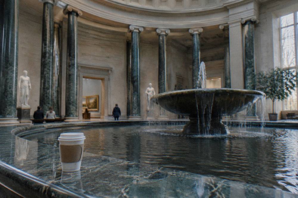 Sunlit rotunda interior of an art museum with a fountain at its center