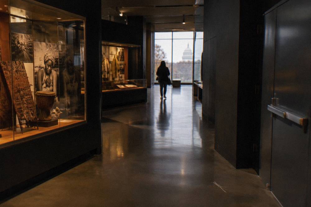 A quiet gallery corridor inside the museum with display cases lit against dark walls