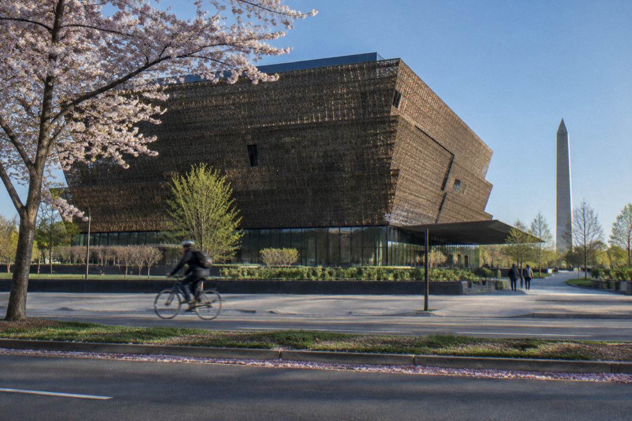 The bronze lattice facade of the National Museum of African American History and Culture on a bright morning
