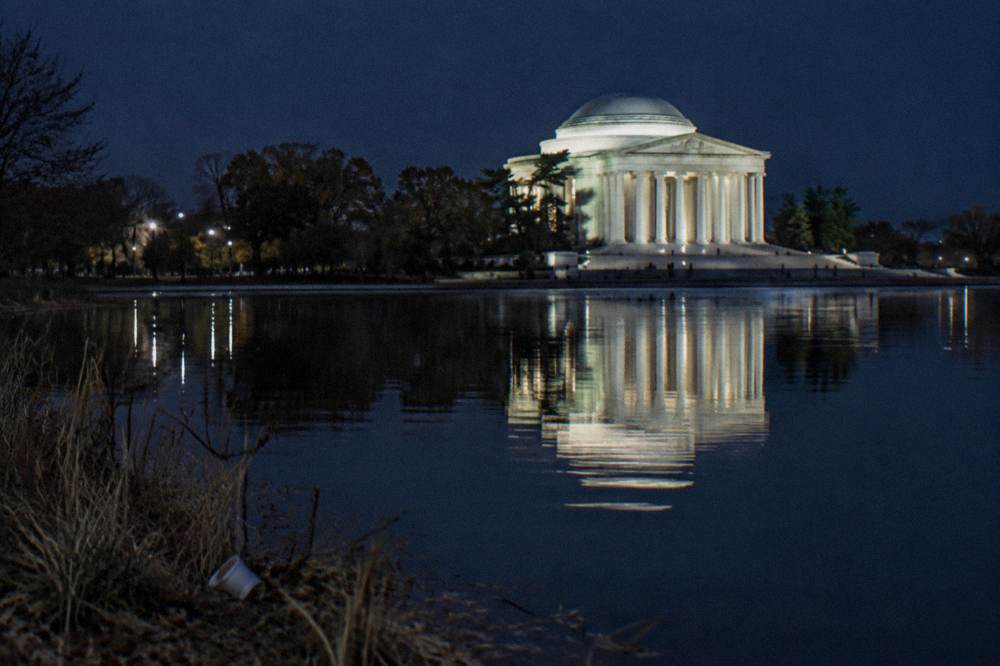 The Jefferson Memorial illuminated at night reflected in the Tidal Basin water