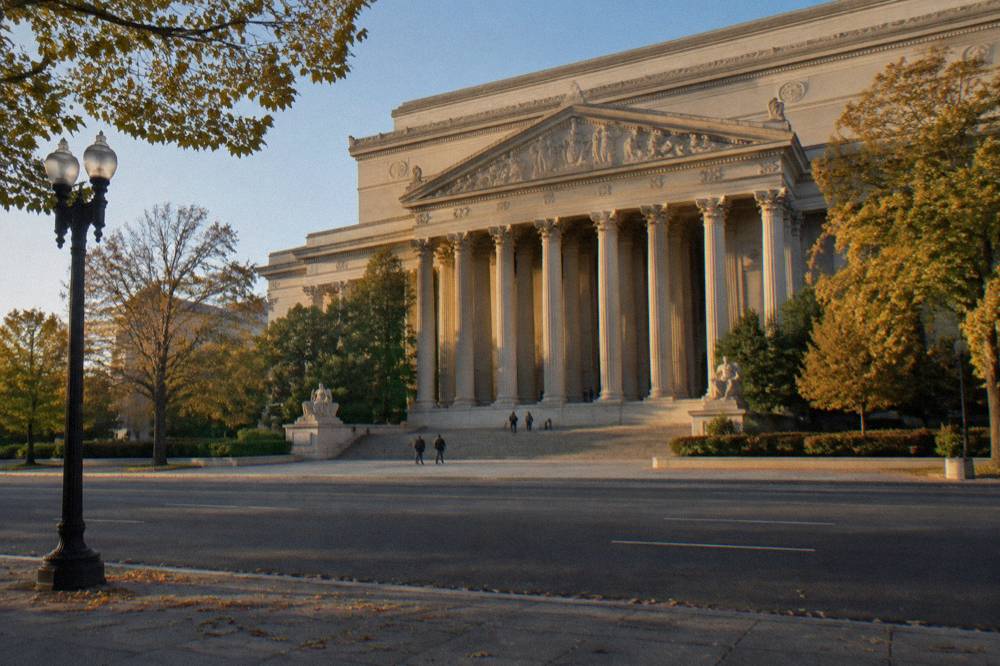 National Archives building facade on Constitution Avenue with visitors at the entrance
