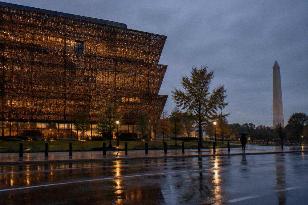 Modern museum exterior with glass facade and a city street in front