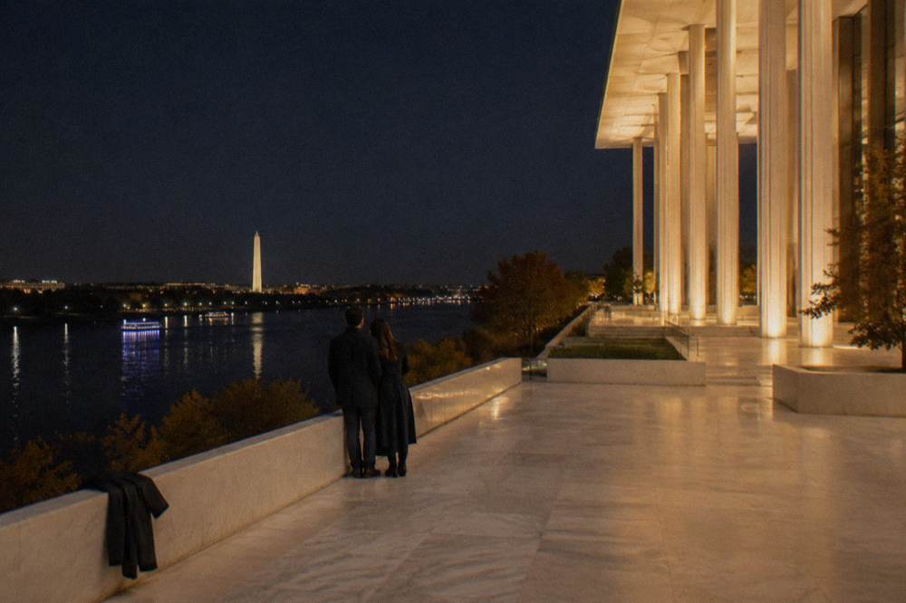 The Kennedy Center building lit at night above the Potomac River with the terrace view toward the water