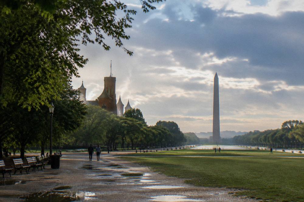 Wide view of the National Mall with the Washington Monument rising above tree-lined lawns