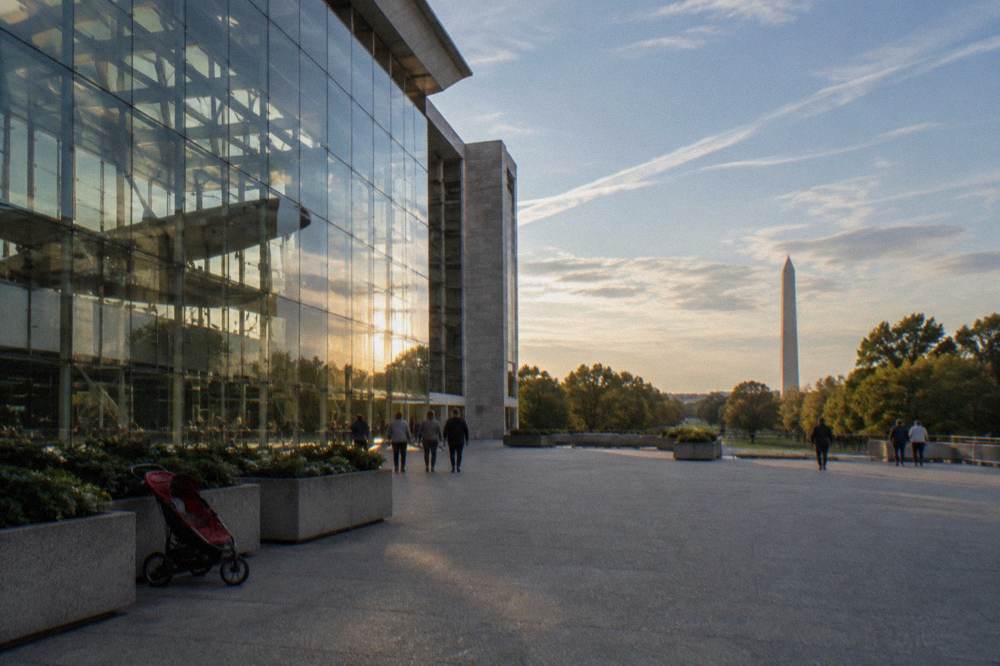 Grand stone museum facade with visitors gathered on wide entrance steps