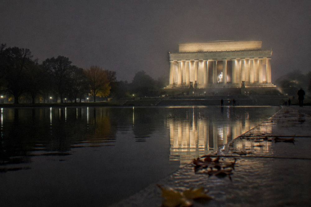 Illuminated Lincoln Memorial and Reflecting Pool at night under a dark sky