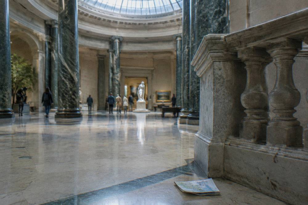 Museum visitors gathered in a bright atrium gallery space