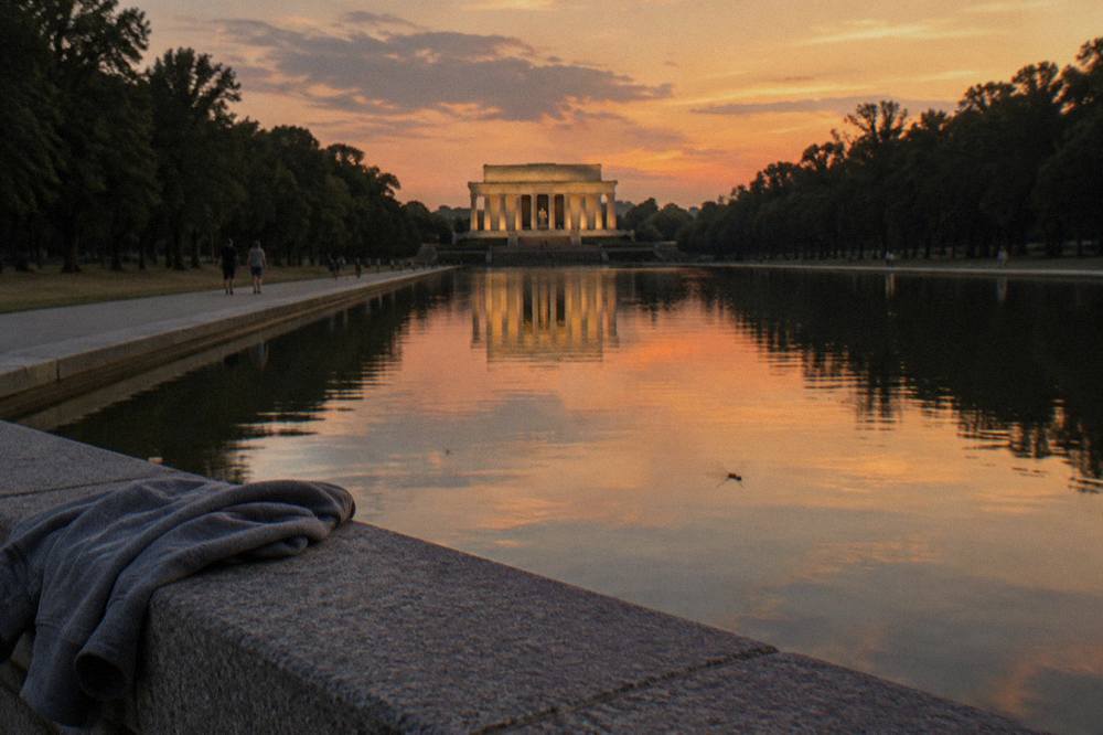 The Lincoln Memorial reflected in the water at dusk with the columns lit warmly