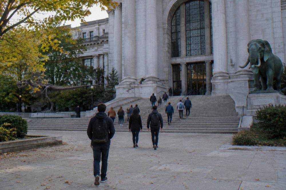 Museum facade on the National Mall with wide stone steps and visitors walking in