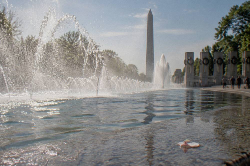 The World War II Memorial fountain with the Washington Monument rising behind it