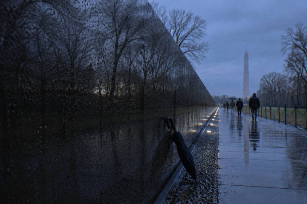 A quiet memorial pathway along the National Mall lined with trees and stone walls