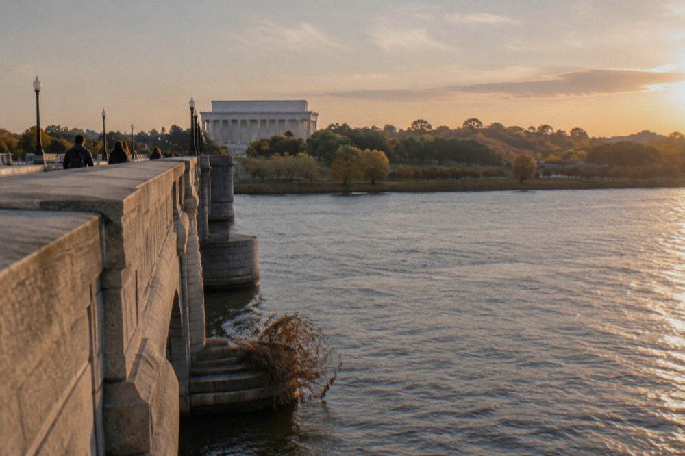 The Memorial Bridge crossing the Potomac River with the Lincoln Memorial behind and Arlington's green hills ahead