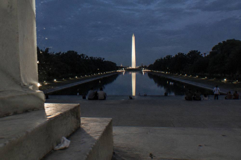 The Lincoln Memorial and Washington Monument lit at night reflecting across the Mall