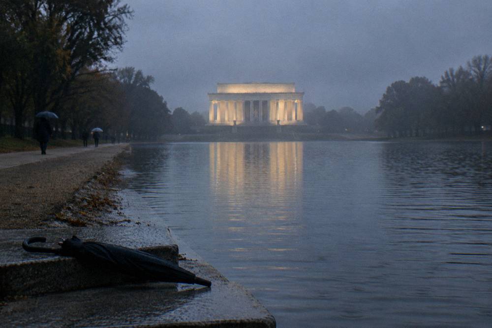 The Lincoln Memorial and its reflecting pool seen from a distance at dusk